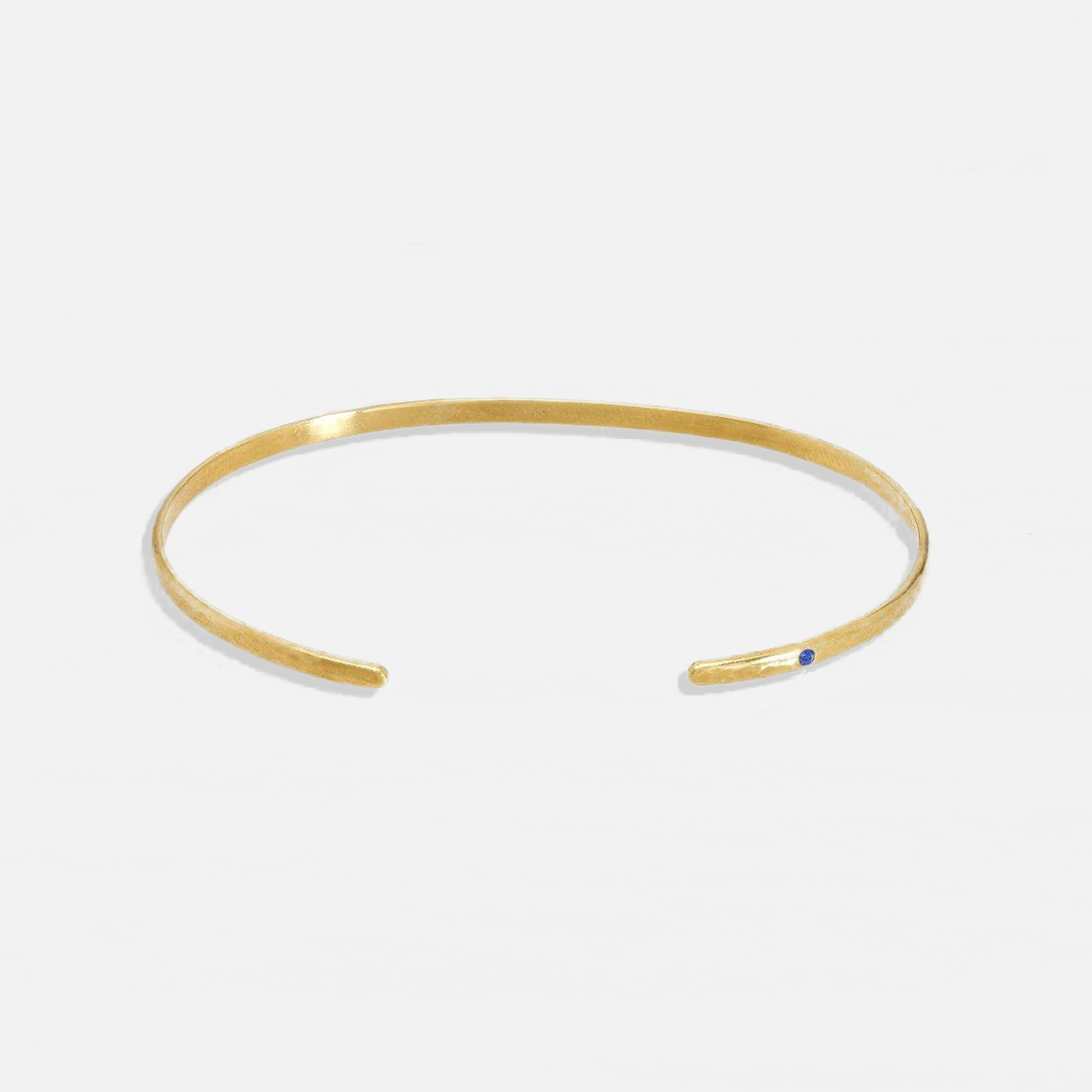 ISHKAR classic oval gold-plated bangle, featuring a small blue gemstone on one end.