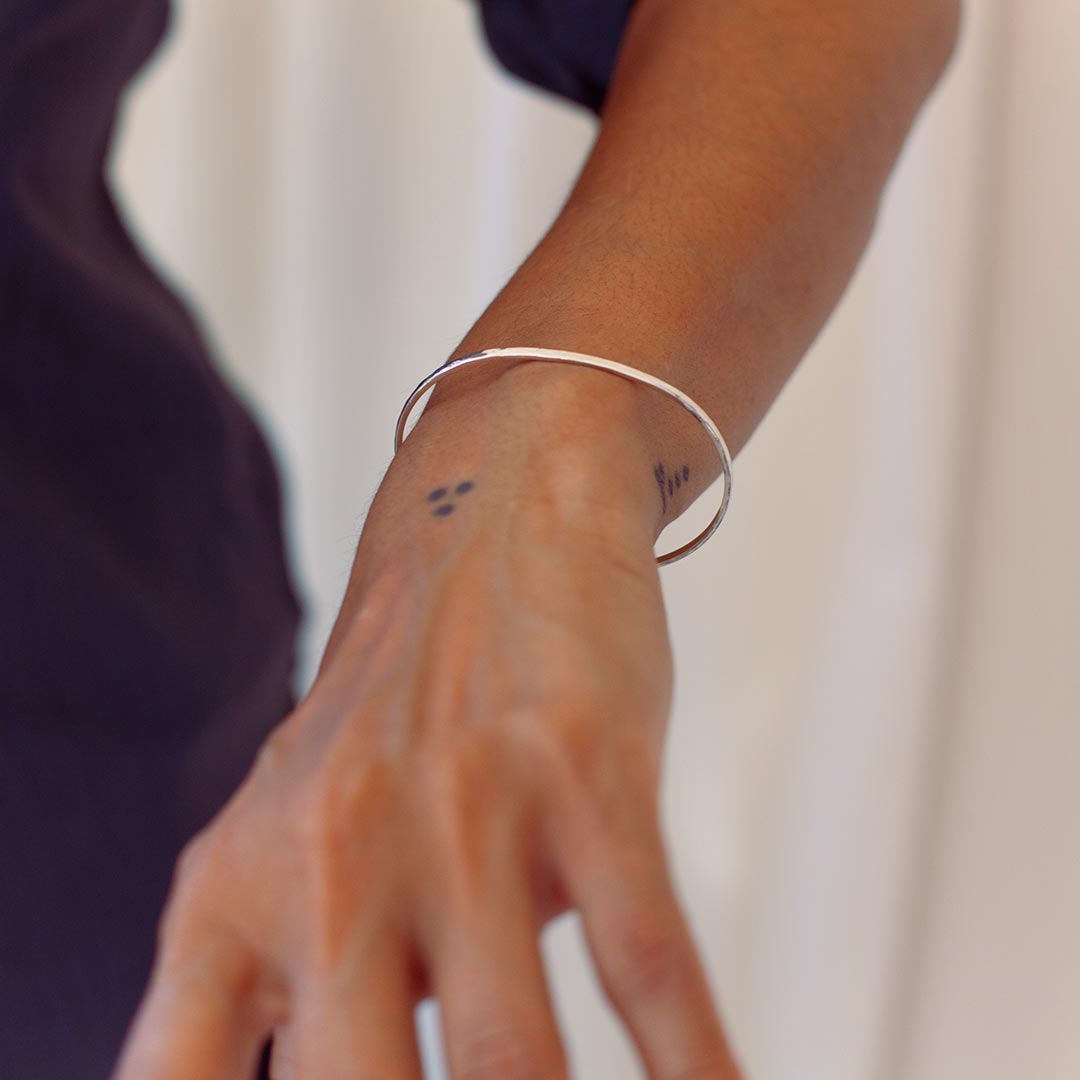 Close-up of a person's wrist wearing ISHKAR's silver bangle