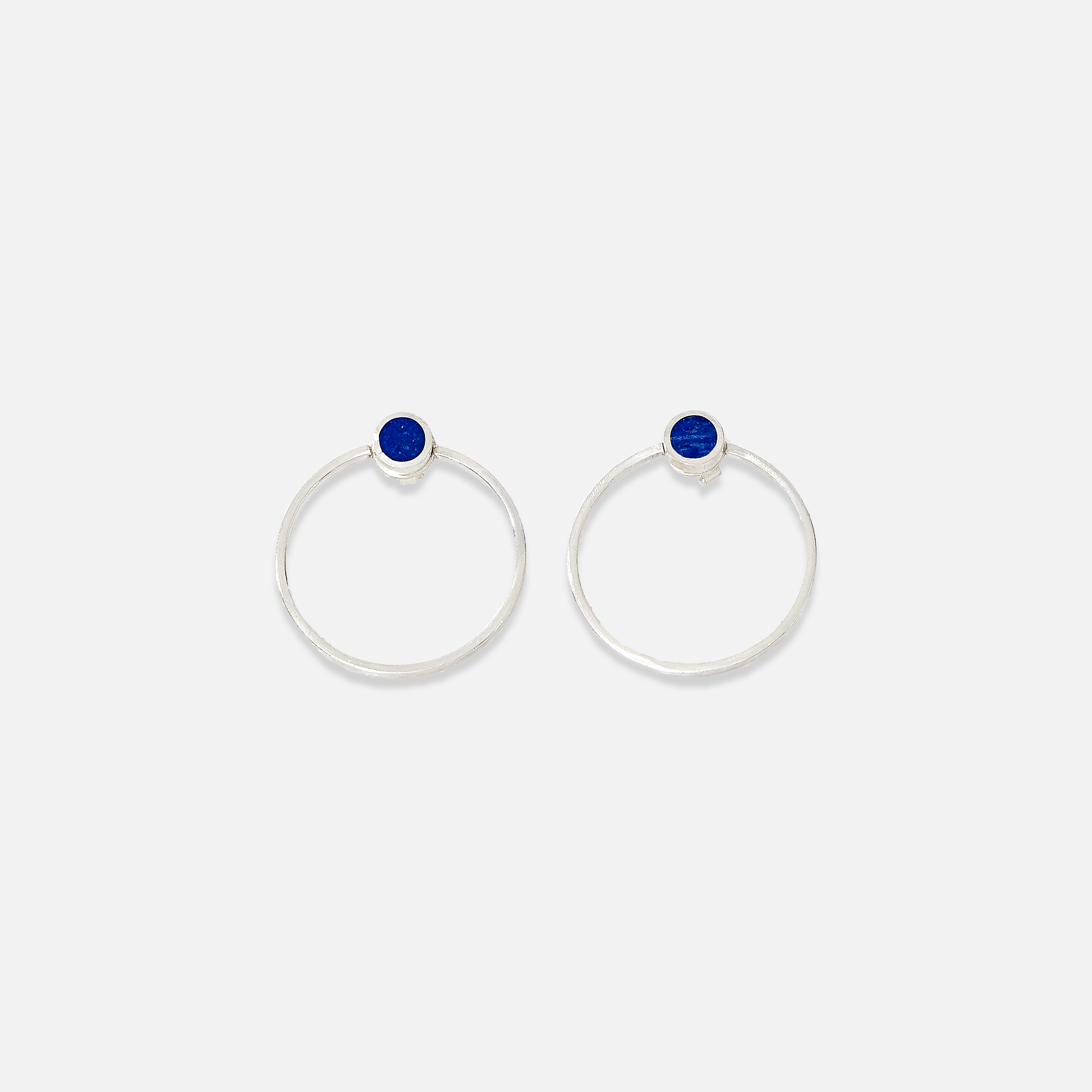 A pair of sterling silver stud earrings with blue lapis lazuli details in the centre.