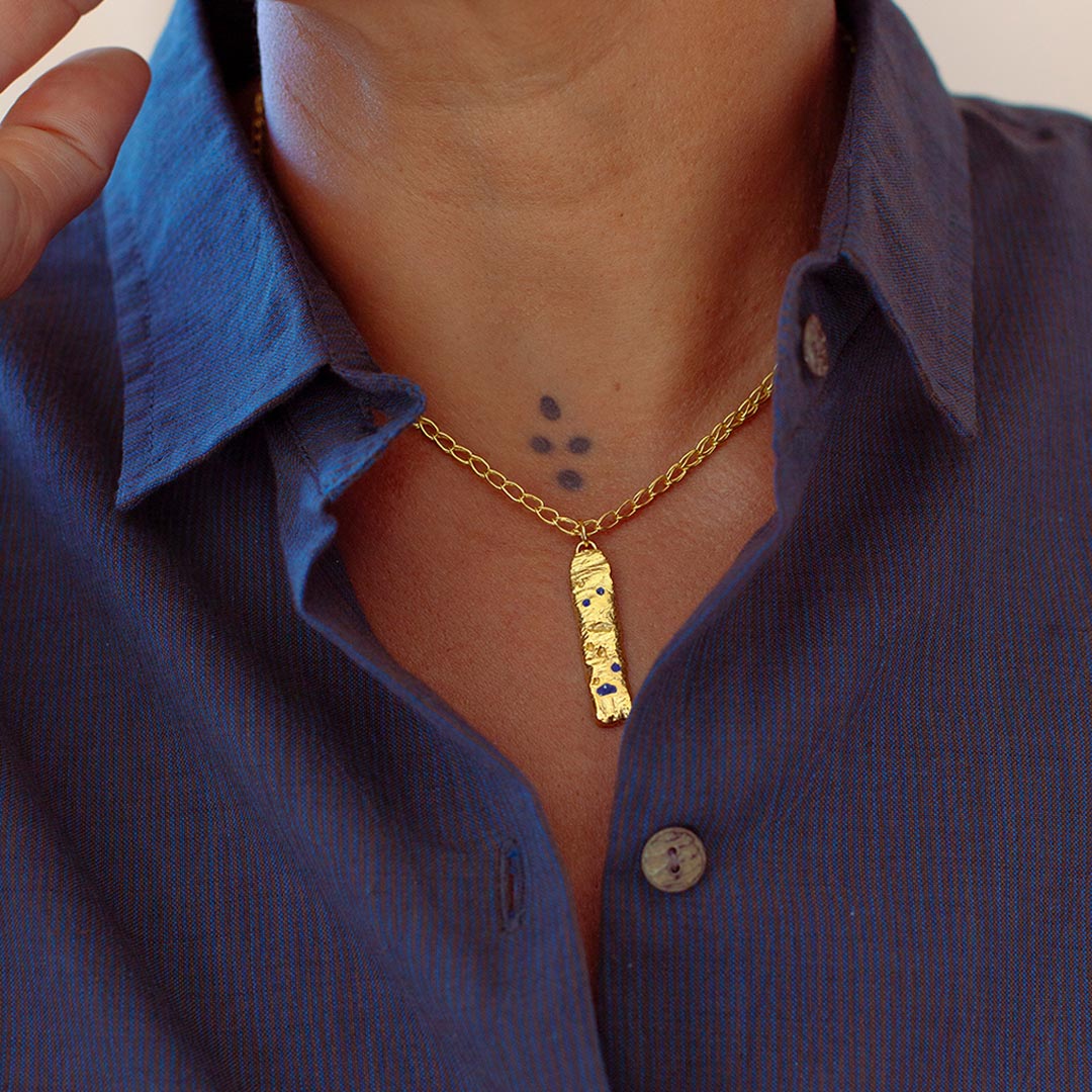 Model wearing gold-plated necklace with lapis lazuli and handmade chain.