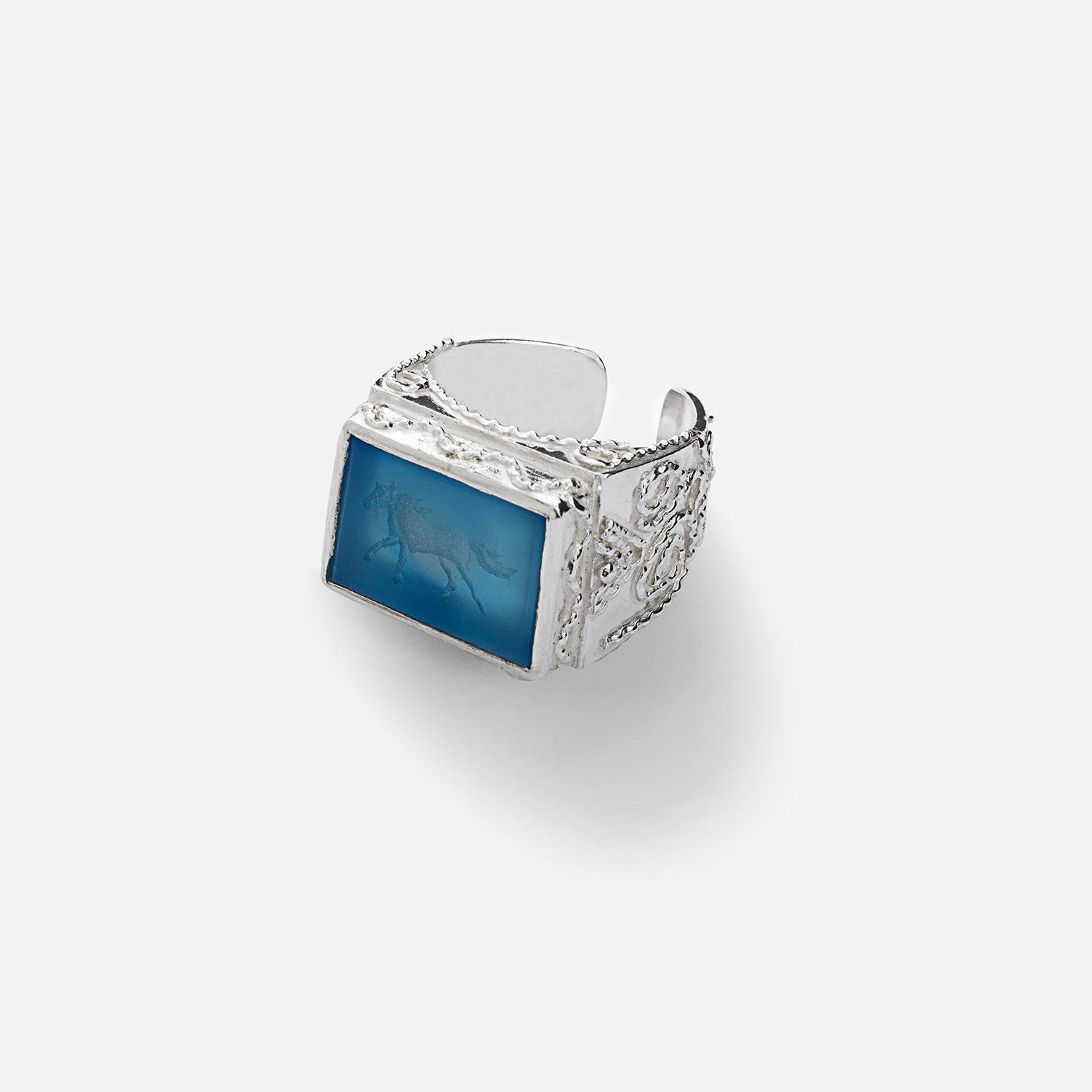 A sterling silver filigree ring with a blue agate stone depicting a silhouette of a galloping horse.