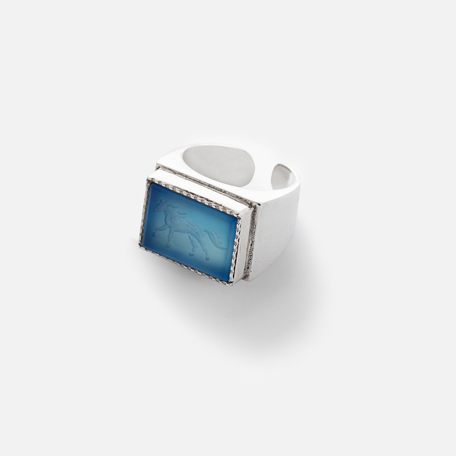 A blue agate ring with a silhouette of a galloping horse etched onto the stone, set in a sterling silver band.