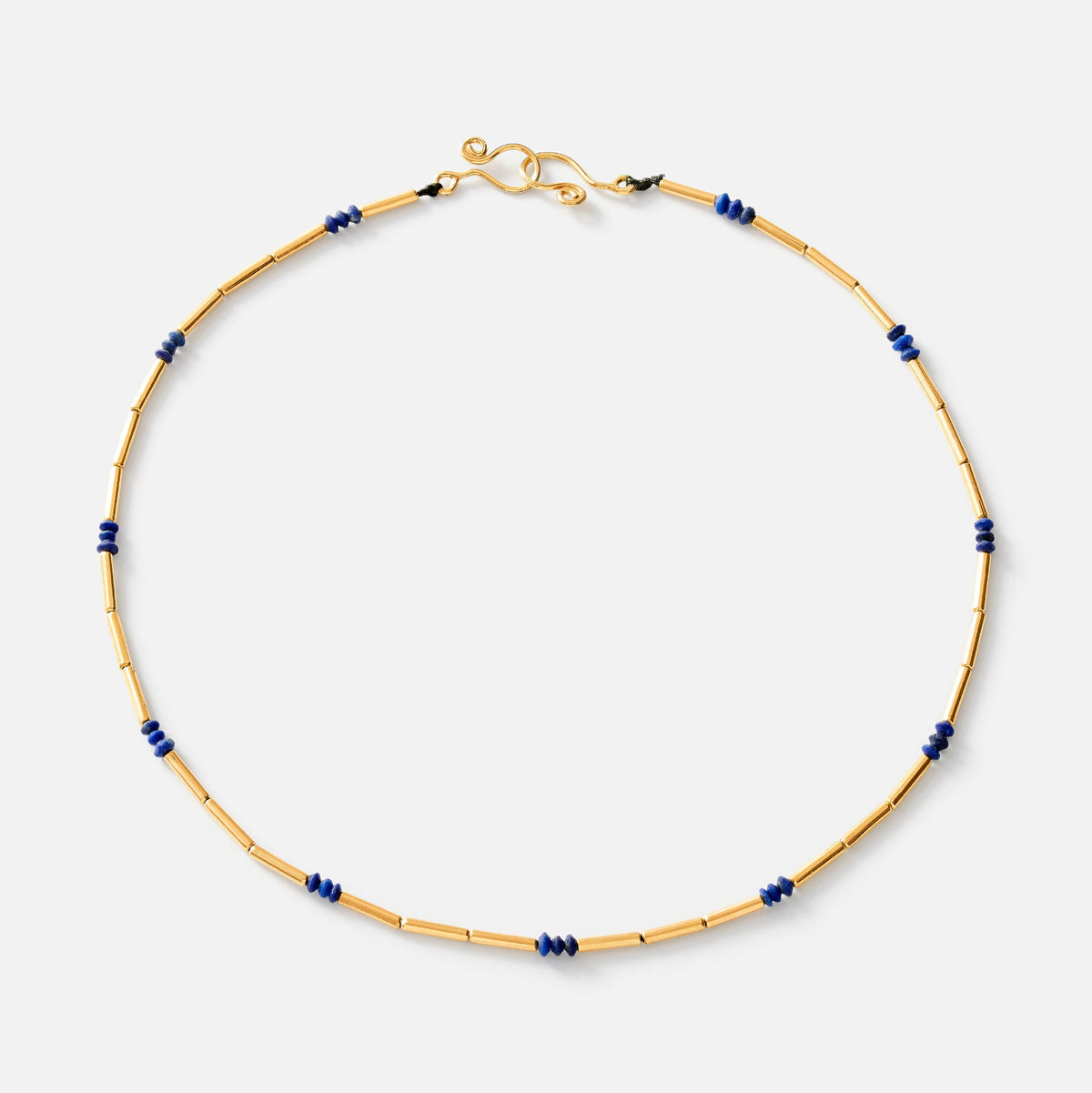 A delicate gold chain necklace with small dark blue bead accents spaced along the chain, featuring a gold clasp, shown on a light gray background.