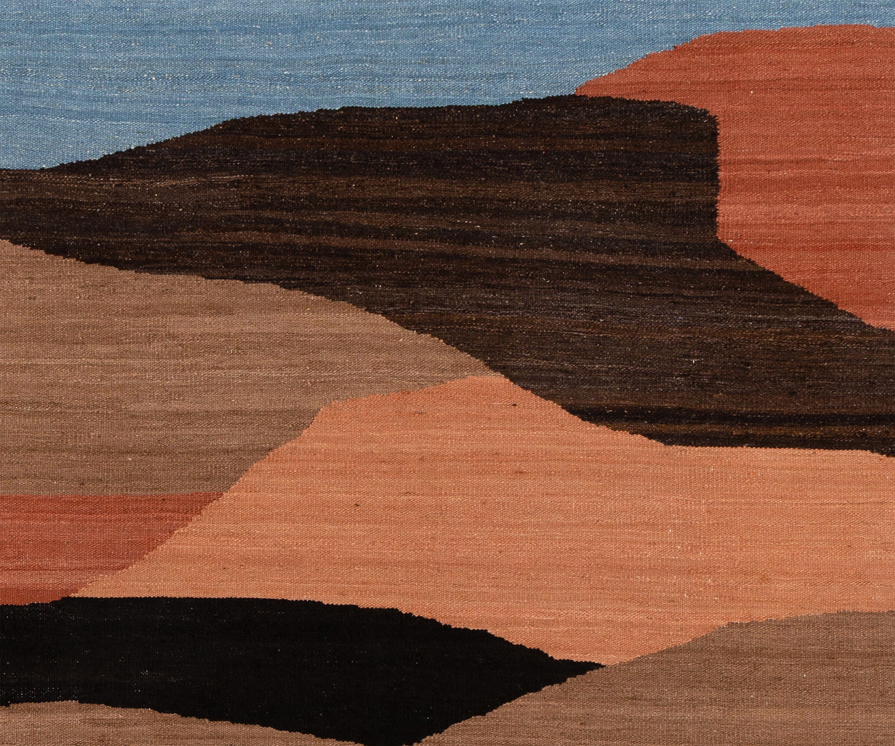 Abstract geometric area rug with layered organic shapes in black, dark brown, terracotta orange, dusty pink, beige, and light blue, showing a visible woven texture.