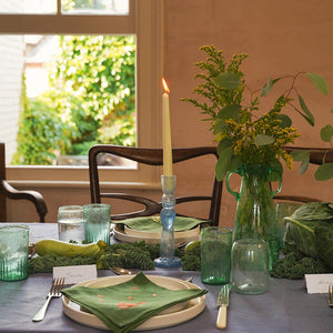 Elegant table setting with greenery, dressed with handblown candlesticks and glasses.