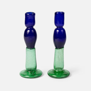 Two blue and green glass candle holders on a white background