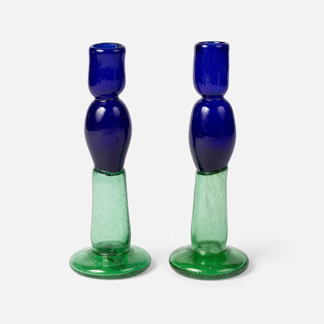 Two blue and green glass candle holders on a white background
