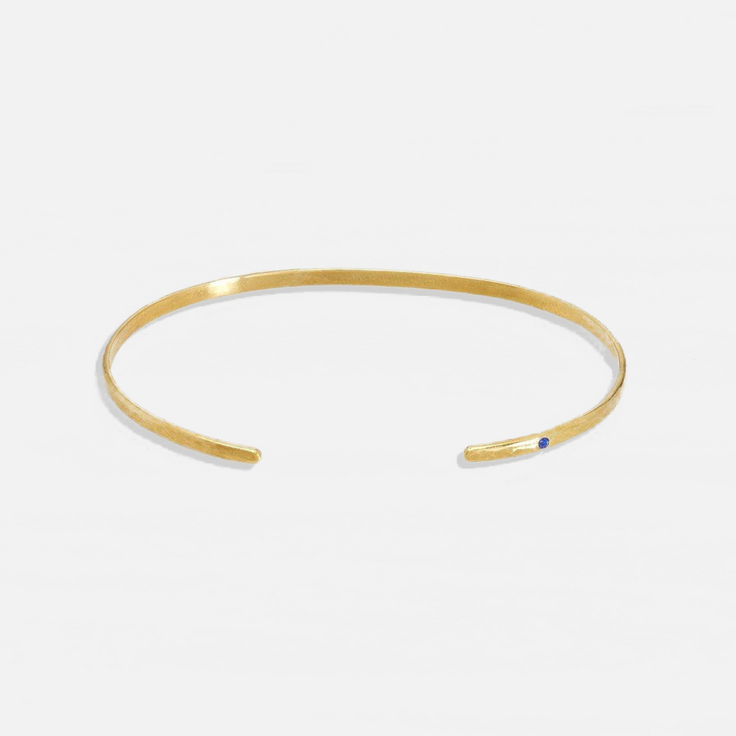 ISHKAR classic oval gold-plated bangle, featuring a small blue gemstone on one end.
