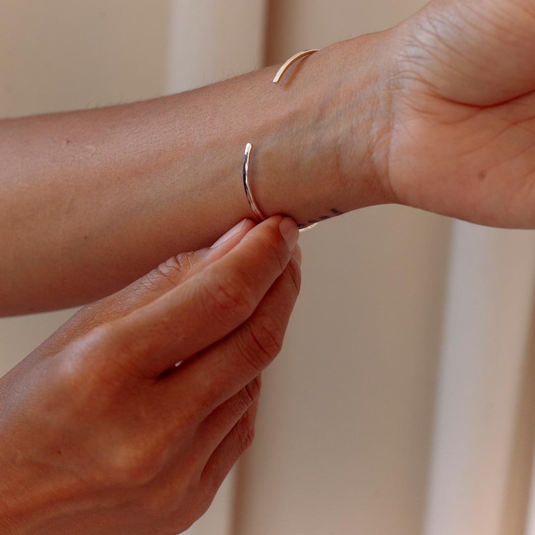Closeup of ISHKAR's silver bangle, adjusted on a wrist.