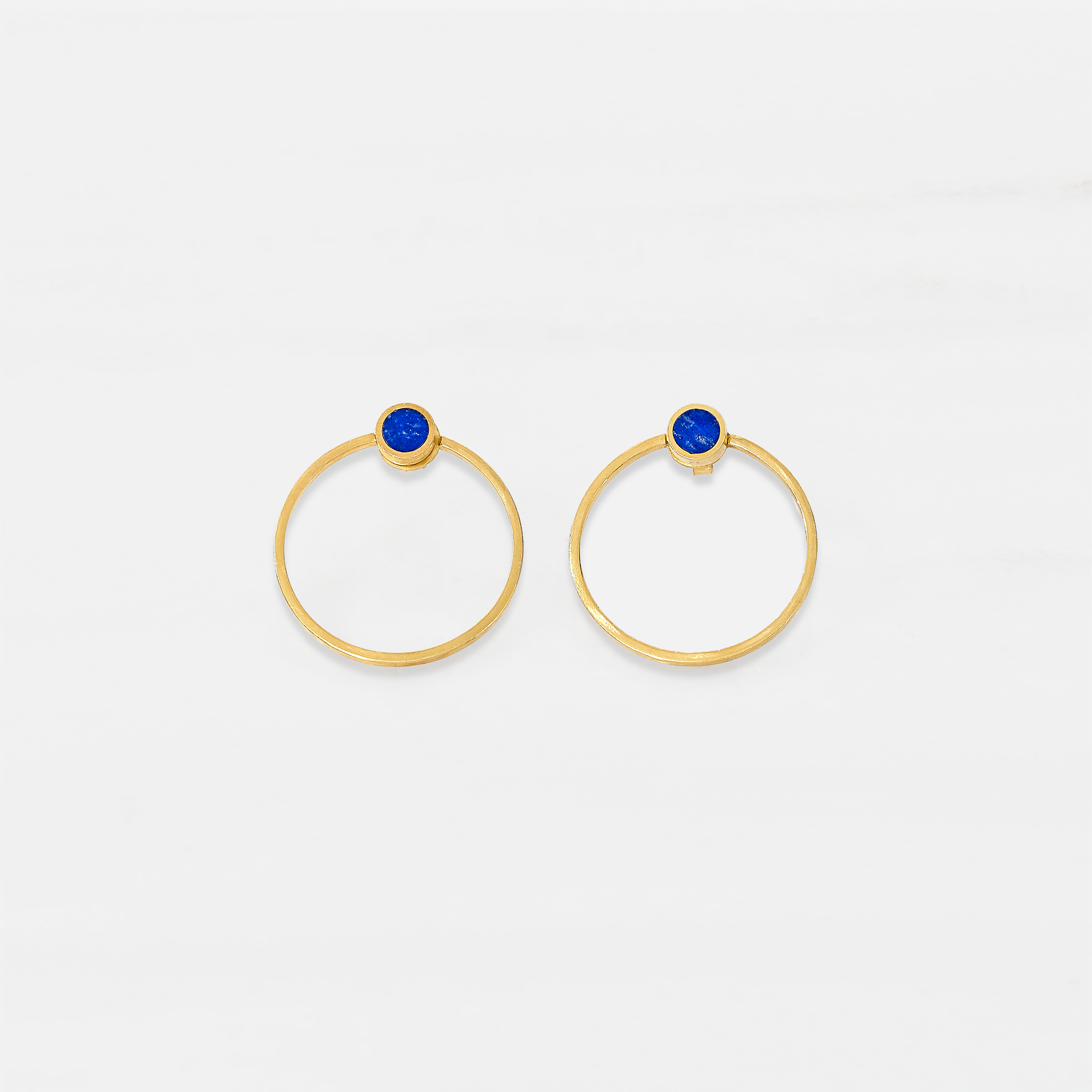 A pair of gold plated sterling silver stud earrings with blue lapis lazuli details in the centre.