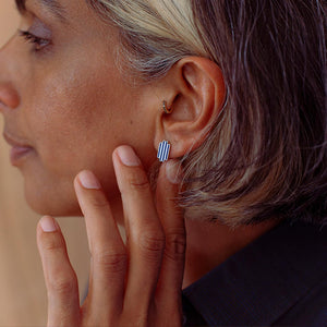 Close-up of a woman wearing sterling silver stud earrings with lapis lazuli.
