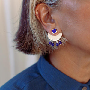 Close-up of a model wearing a sterling silver earring with lapiz lazuli stones.