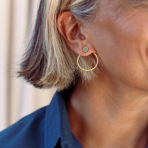 Close-up of a person wearing gold-plated sterling silver earrings with Bamiyan turquoise.