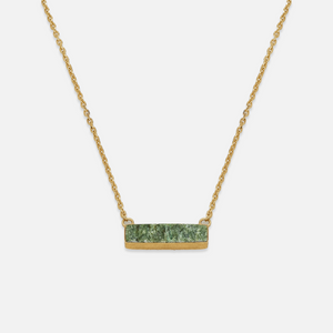 A necklace with a sterling silver chain and a hewn turquoise pendant.