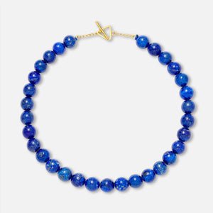 A lapis lazuli bead necklace with a gold clasp, displayed against a white background.