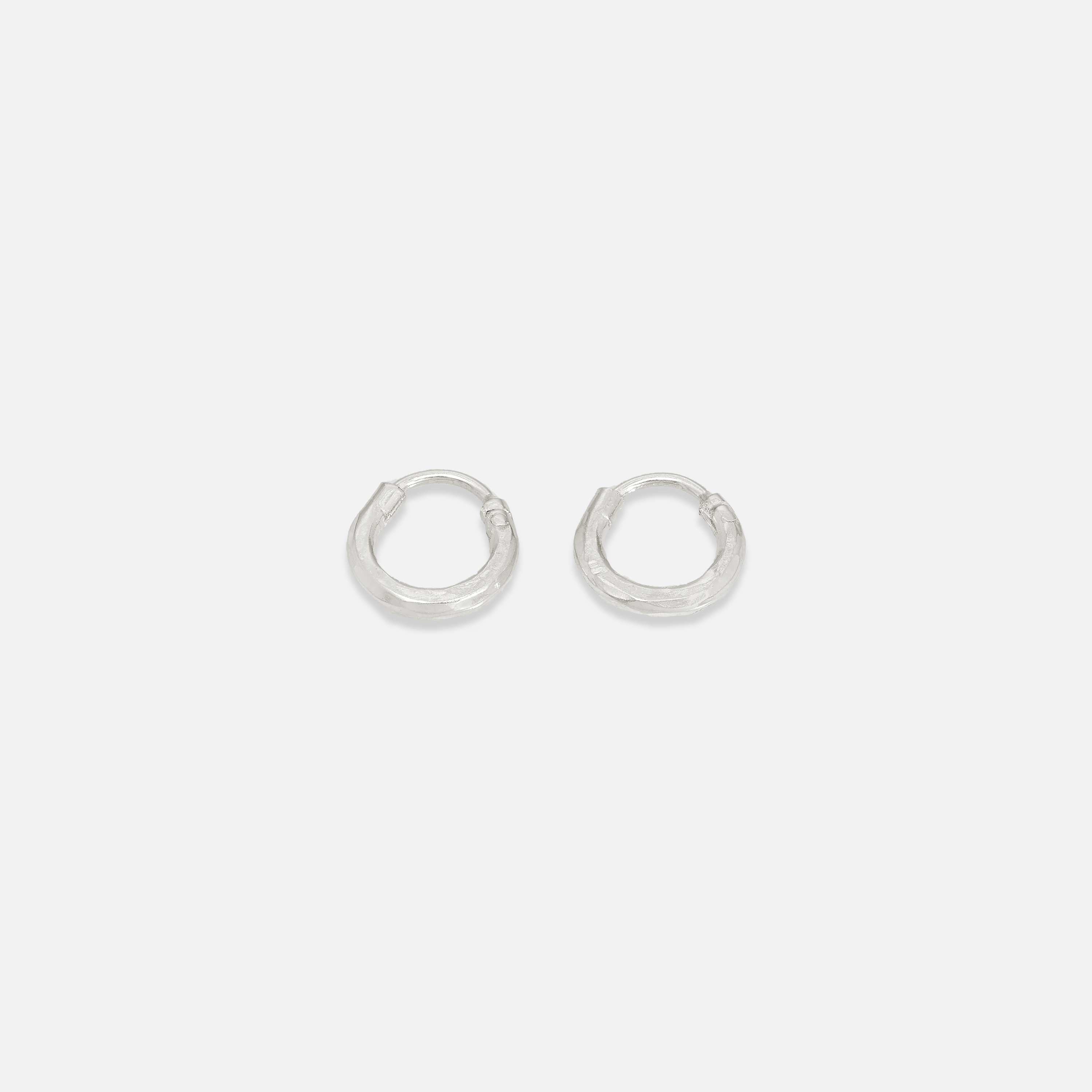 A pair of small gold-colored hoop earrings on a white background