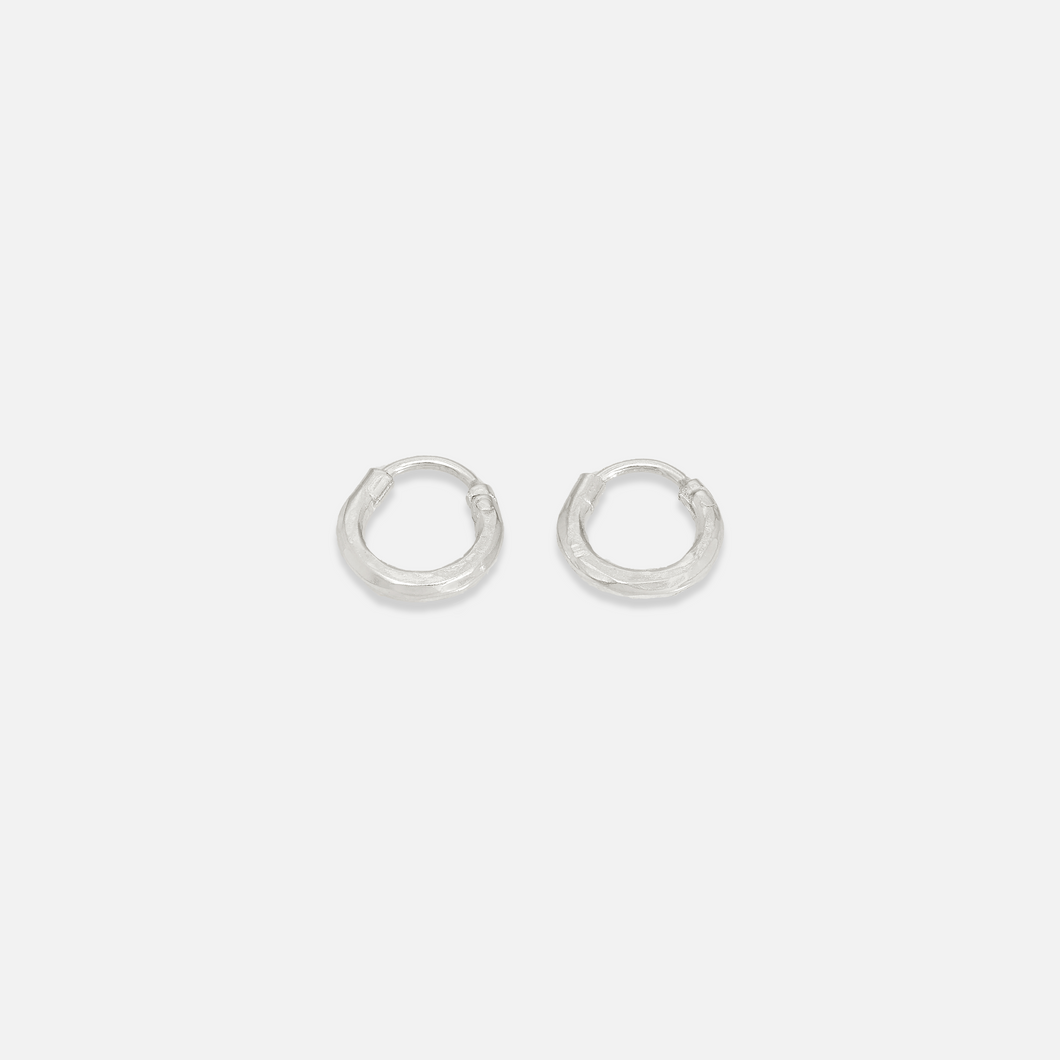 A pair of small gold-colored hoop earrings on a white background