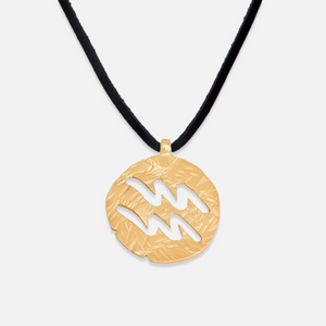 A gold-plated sterling silver pendant with hand-hammered details, suspended from a black cord.