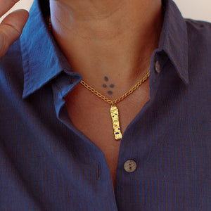 Model wearing gold-plated necklace with lapis lazuli and handmade chain.