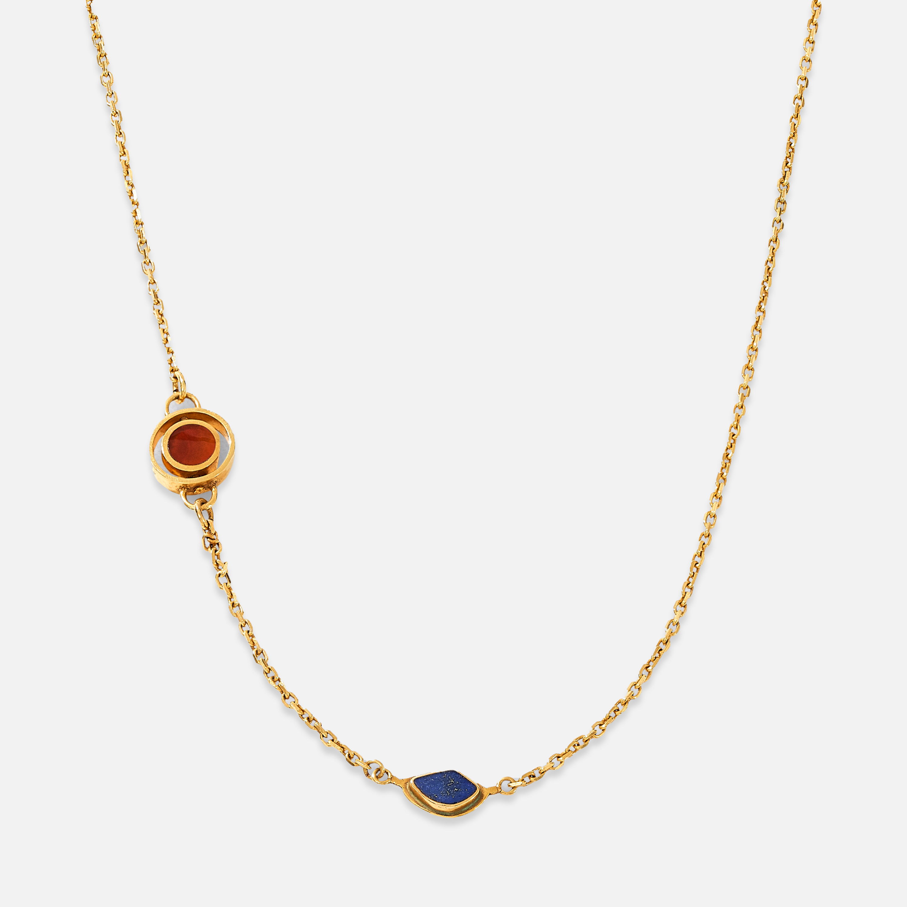 A gold-plated sterling silver necklace with asymmetrical double charms, featuring Lapis and red Agate stones, displayed against a white background.