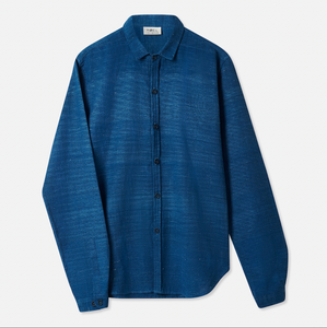 A long-sleeved indigo blue cotton shirt with a classic collar, button-down front, and a curved hem.
